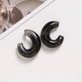 Macro detail of translucent smoky gray resin C-shaped earrings with ink marble texture - Black