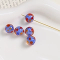 Macro view of 10mm light blue glass beads with colorful dots and pre-drilled holes - Dark Blue