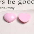 Macro shot of glossy pink heart-shaped resin charms for DIY jewelry and hair accessories - Pink
