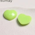 Macro shot of two neon green acrylic heart charms with polished mirror finish for DIY - Green