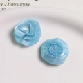 Macro detail of light blue resin rose charms with iridescent texture for DIY hair accessories - Blue