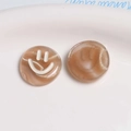 Macro shot of two brown resin smiley face charms for DIY hair accessories and jewelry - Pink Coffee White Glitter