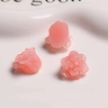 Macro shot of three soft pink resin rose charms on a white ceramic tray for DIY jewelry - Jelly Pink