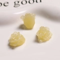 Detailed close-up of three pale yellow resin rose charms for DIY jewelry making - Jelly Yellow