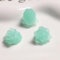 Dettaglio macro di tre ciondoli a forma di rosa verde chiaro in resina per gioielli fai-da-te - Verde Gelatina