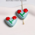 Light blue heart-shaped tulip bead with red flower painting on a gold pin - Blue