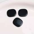 Close-up of polished black resin square cabochons for DIY jewelry and hair accessories - Black