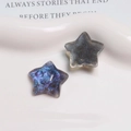 Vue détaillée des breloques étoiles en résine aurore violette et bleu pailleté pour bijoux - Noir
