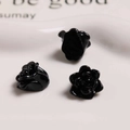 Macro shot of three glossy black resin rose flower beads for DIY jewelry and accessories - Black