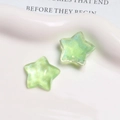 Close-up of star-shaped resin charms with shimmering blue glitter on a white ceramic tray - Light Green