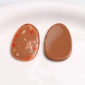Macro view of oval resin pendants with embedded wood chips for DIY jewelry making - Brown