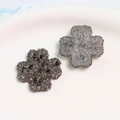 Detalle de dijes de resina de trébol brillante en colores negro humo y plateado - Trébol de cuatro hojas