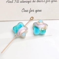 Detailed macro view of star-shaped rainbow resin charms with a gold pin on white surface - Dark Blue