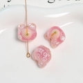 Gros plan de perles d'ours en résine rose pailletée avec motif blanc pour bijoux - Rose rouge