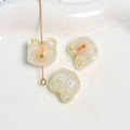 Gros plan de breloques ours en résine scintillante avec motifs X et O pour bijoux DIY - Blanc Cassé