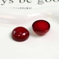 Vista macro di due cabochon in resina rosso intenso con glitter su vassoio in ceramica - Rosso