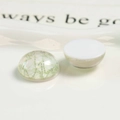 Macro view of semi-round resin cabochon with green mesh texture and flat white back - Green