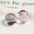Vue macro de deux perles en résine rose translucide pour la création de bijoux DIY - Rose Clair