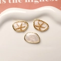 Macro detail of starfish pendants and pearlescent resin charms on a ceramic tray - Gold Edge White Starfish