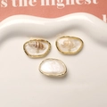 Detailed view of DIY earring charms with embedded shells and pearls in gold metal frames - Gold Edge Ocean Conch