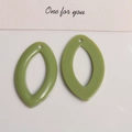 Détail macro de pendentifs d'oreilles ovales évidés en résine vert herbe lisse - Vert