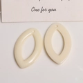 Vue macro de pendentifs feuilles en résine crème pour boucles d'oreilles DIY au fini lisse - Blanc