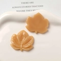 Close-up of caramel resin maple leaf charms with detailed veins for DIY jewelry making - Dark Coffee