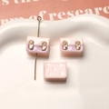 Detailed macro view of resin backpack charms with metal pins for DIY jewelry making - Light Pink