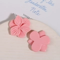 Detail of pink resin flower hair clips and floral accessories on a ceramic tray - Pink