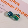 Macro shot of 3D resin hamburger DIY bead with glossy blue polka dot finish and vibrant layers - Blue