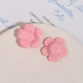 Detalle macro de dos flores de resina rosa para joyería DIY en bandeja de cerámica - Rosa