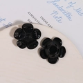 Dettaglio di ciondoli neri a forma di fiore in resina 3D con finitura lucida - Nero