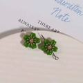 Macro shot of green alloy flower earring with golden stamen and silver needle detailing - 1 Piece / Green