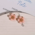 Detailed view of pink resin cherry blossom flower charms with golden center on ceramic tray - 1 Piece / Light Orange