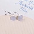 Macro detail of lavender jelly acrylic stud earrings with silver pins on a ceramic dish - Blue
