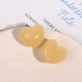 Dettaglio di orecchini a cuore in resina giallo miele su un vassoio di ceramica - Stile Cuore Crema Jelly