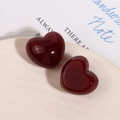 Primo piano di ciondoli a cuore in resina rosso scuro lucido per gioielli e accessori DIY - Stile Cuore Bordeaux Jelly