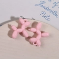 Detalle de colgantes de resina rosa con forma de perro globo para manualidades en bandeja - Rosa