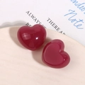 Dettaglio di ciondoli a cuore in resina rosso scuro lucida su un piatto di ceramica - Stile Cuore Viola Jelly