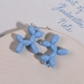 Detalle de los colgantes de perro globo en acrílico azul claro sobre plato cerámico - Azul
