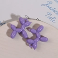Detalle macro de colgantes de perro globo de acrílico morado brillante con agujeros para colgar - Púrpura