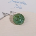 Close-up of green water ripple glass bead pendant with textured surface and transparent loop - Light Green