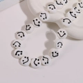 Macro shot of 14mm white round glass beads with black smiley face design on ceramic tray - Smile Face Style / 1 Piece / White