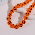 Macro view of 14mm orange glazed smiley face beads in a white ceramic heart tray - Smile Face Style / 1 Piece / Orange