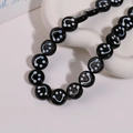 Detailed view of 14mm round glass beads featuring white smiley face patterns on black finish - Smile Face Style / 1 Piece / Black