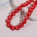 Macro detail of red 14mm round lampwork smile face beads on a wavy ceramic tray - Smile Face Style / 1 Piece / Red