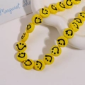 Macro detail of yellow marble glass beads with black smile face patterns on a ceramic tray - Smile Face Style / 1 Piece / Yellow