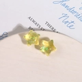 Vue macro de breloques étoiles en résine Aurora avec paillettes irisées dans un plat - Jaune