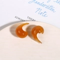 Nahaufnahme französischer Vintage C-Form Tropfenohrringe mit bernsteinfarbener Marmorierung - Ingwergelb