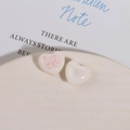 Close-up of heart-shaped resin charms with pink bow relief for DIY jewelry making - Pink